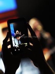 A fan snaps photos on her cell phone